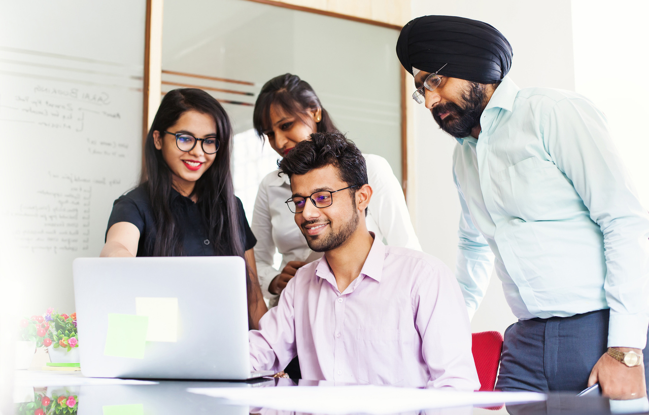 Indian team working together and looking on a screen of laptop